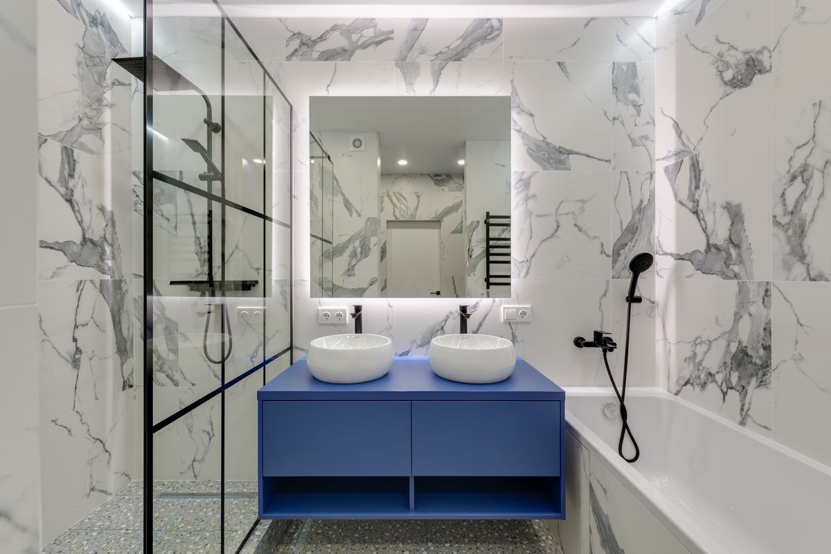 Modern bathroom with a glass shower, twin vessel sinks and a bathtub, three more fixtures that can draw softened water at the same moment