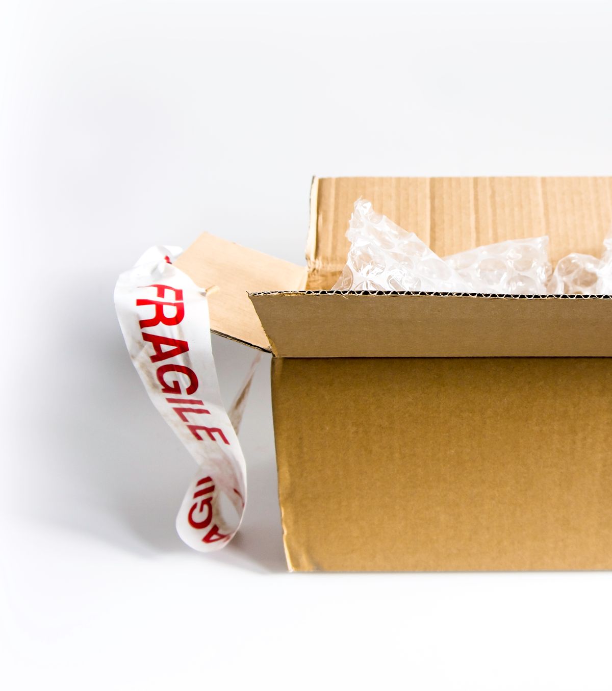 Open cardboard shipping box with a fragile sticker and bubble wrap on a white surface, the original packaging most water softener return policies require