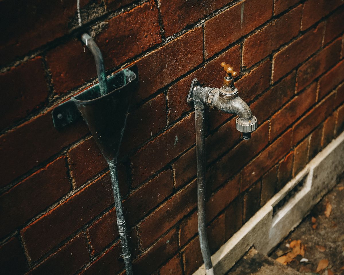 Close-up of a rusty tap showing heavy mineral and corrosion buildup around the outlet