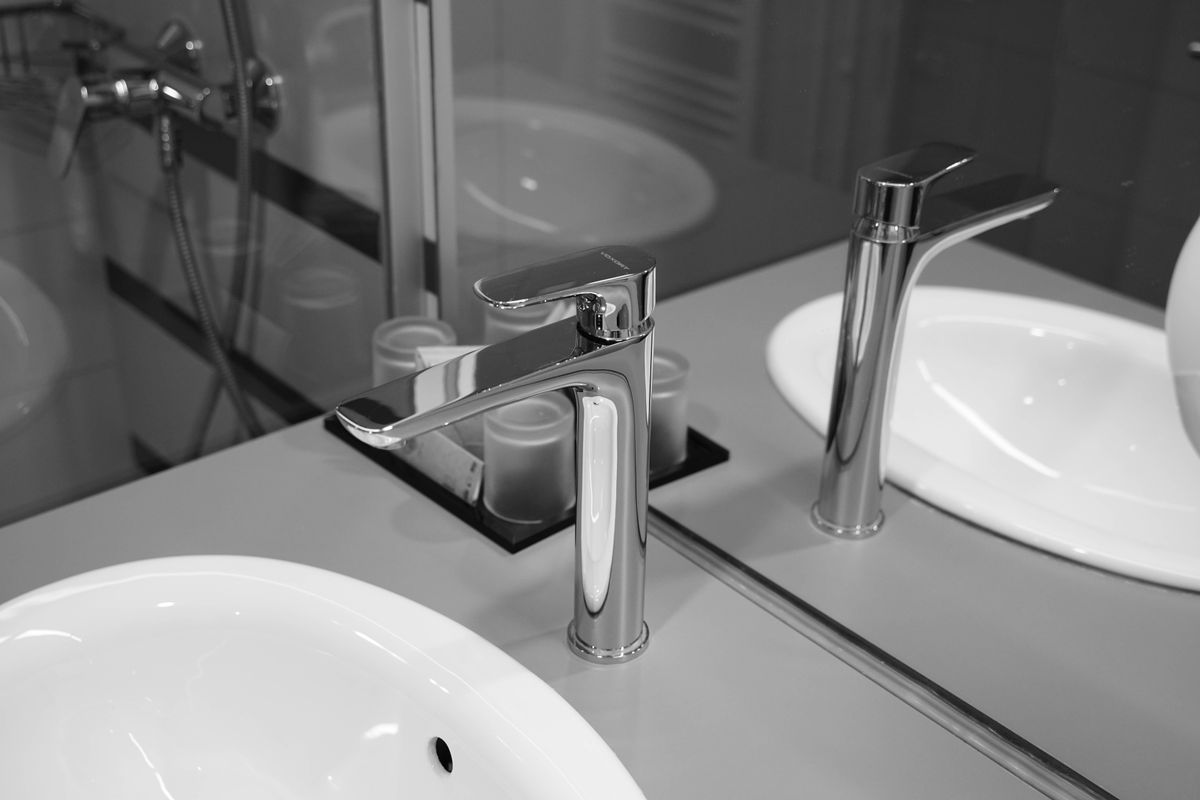 Chrome bathroom faucets over white basins, the fixtures where a SpringWell FutureSoft salt-free conditioner is meant to cut new scale but not water spots