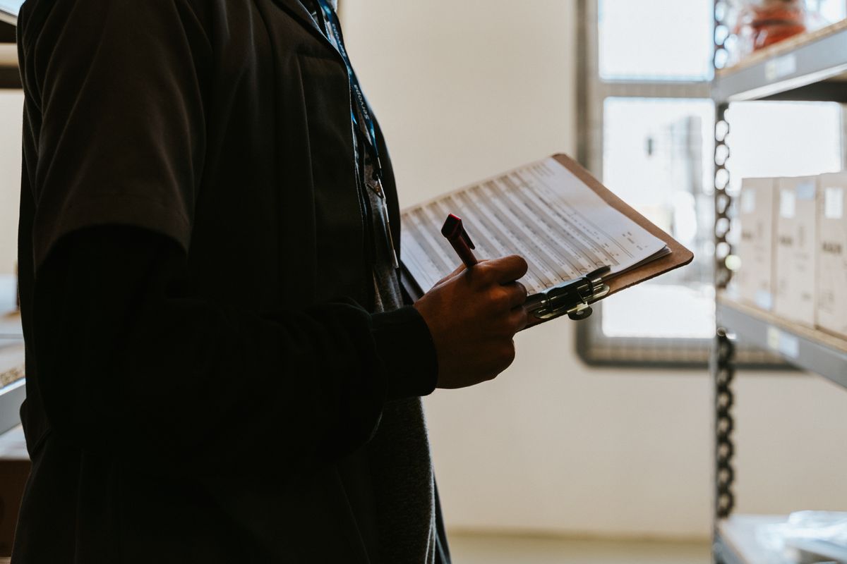 Close-up of a person ticking items off a checklist with a pen, the quick monthly routine that keeps a water softener on schedule