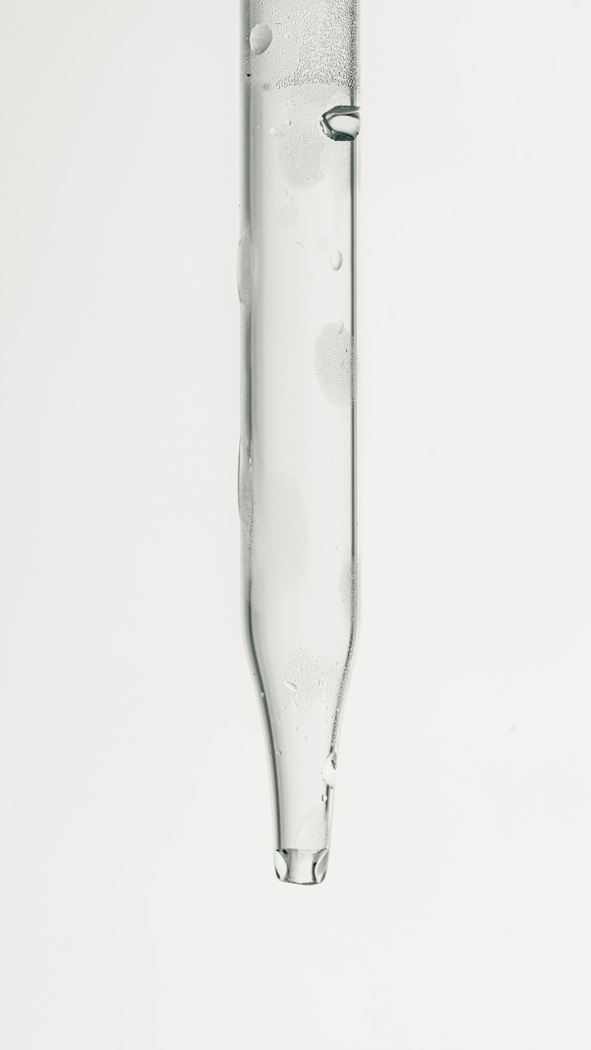 Close-up of a glass dropper with water droplets, the tool that makes each drop of titrant count as one grain of hardness