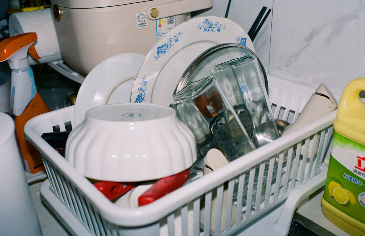 Clean kitchenware and glasses drying on a rack, the surfaces where a silica haze shows most clearly