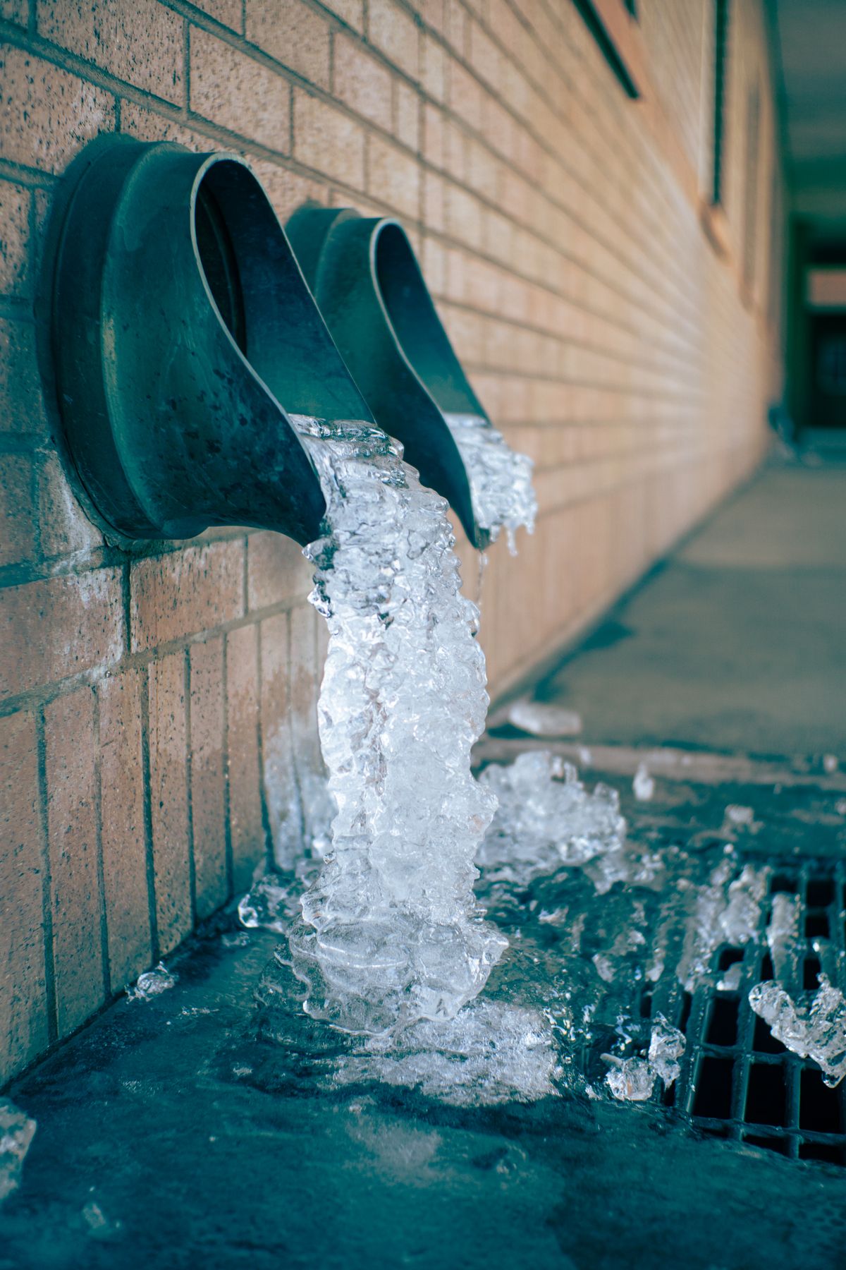 Water pouring steadily out of the open end of a pipe, similar to the rush of backwash and rinse water a softener sends down its drain line during regeneration