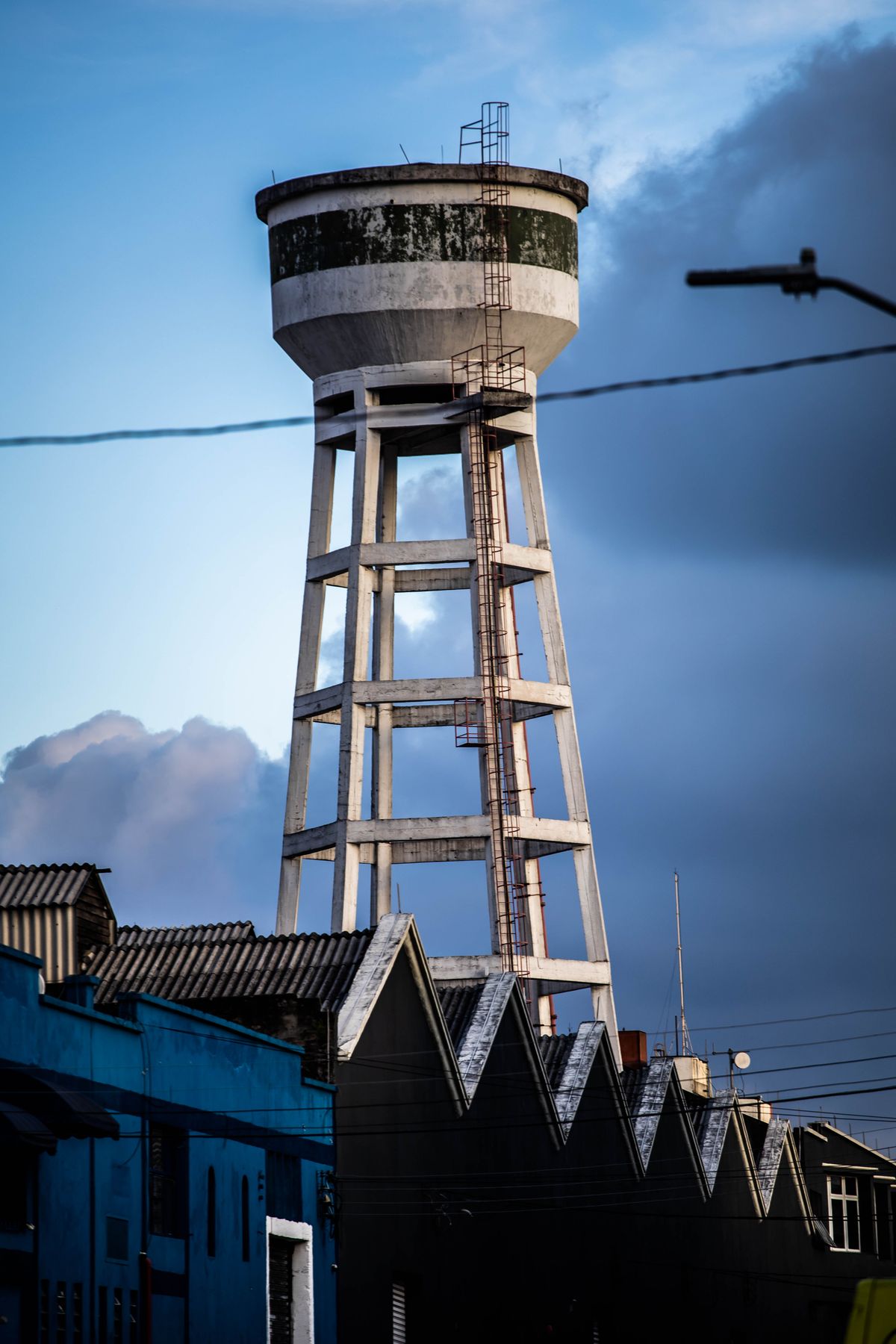 Concrete municipal water tower above town rooftops, representing the utility system a water quality report summarises