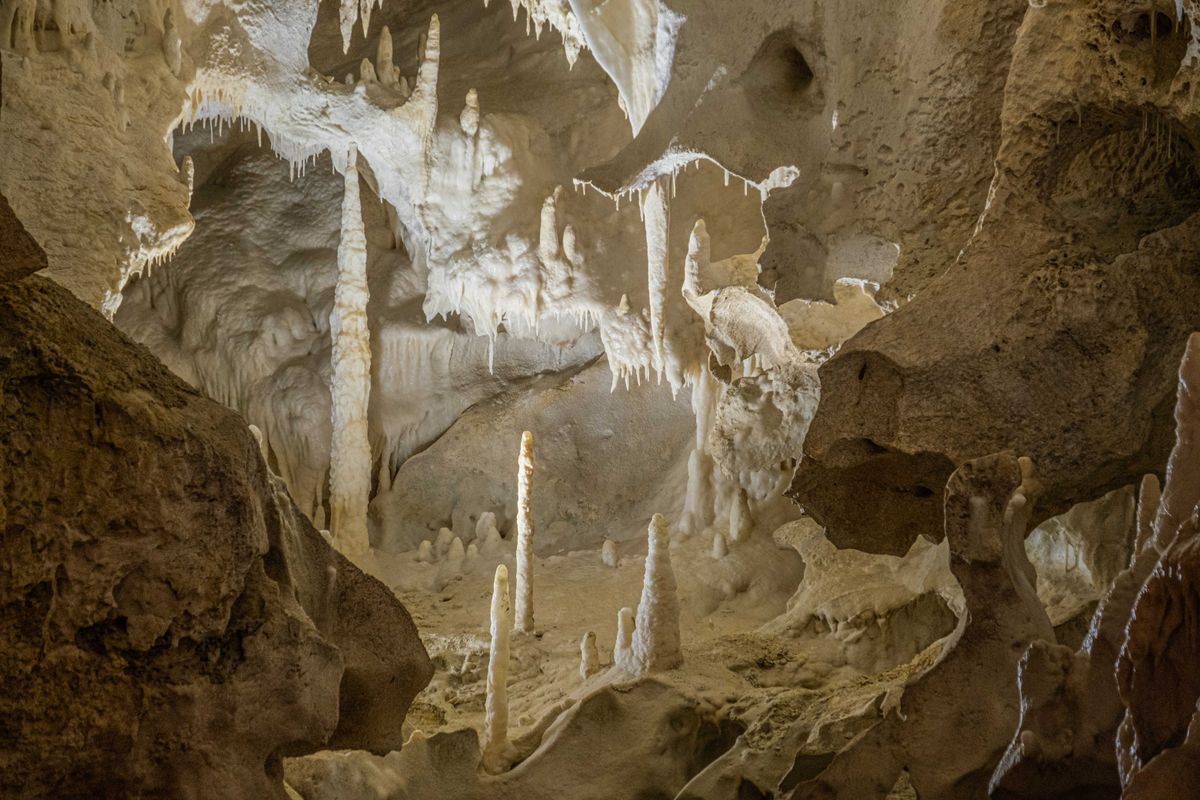Limestone cave interior with stalactites and stalagmites formed by carbonic acid dissolving and redepositing calcite