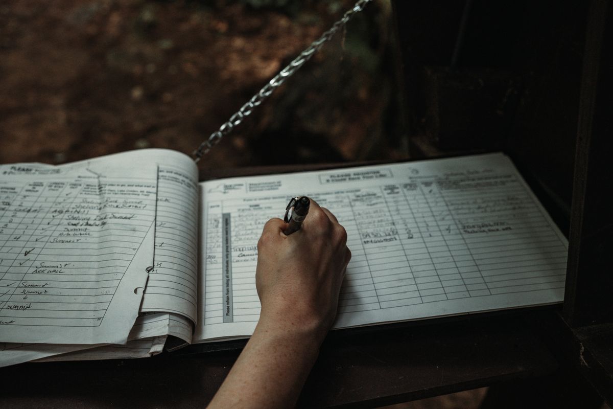 Hand writing dated entries into the ruled columns of a paper logbook, used here to track whether a water softener is declining or has just failed