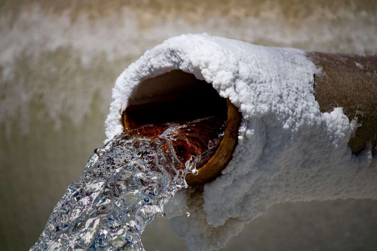 Water running from a rusted pipe over mineral deposits, the visible result of iron that was never measured before a softener was sized