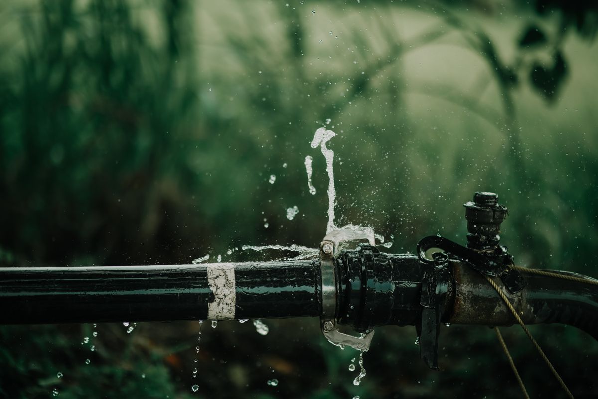 Water leaking from a joint in an outdoor pipe, similar to the steady leak-by of a worn brine valve seat letting water into a softener tank