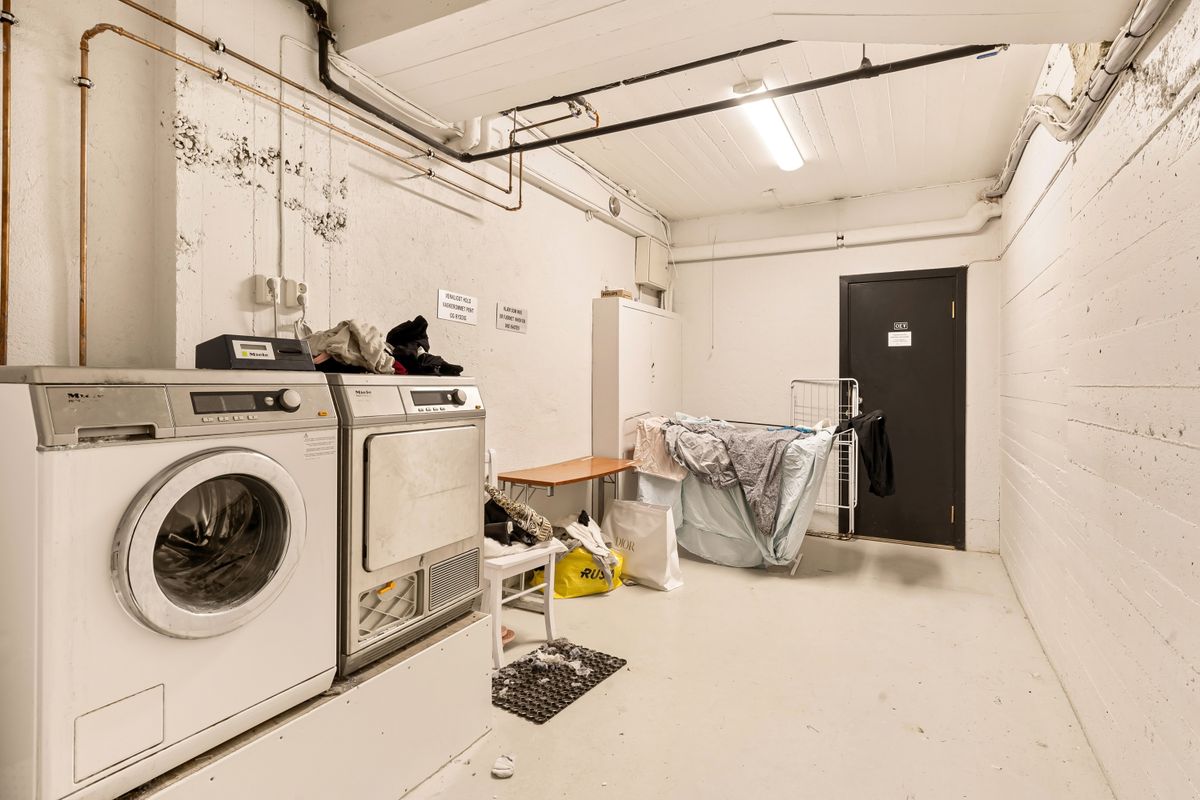 Home laundry room with a washing machine, shelving and exposed supply piping, one of the heaviest users of softened water in a household