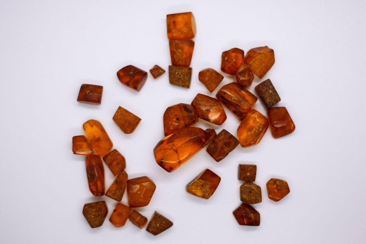 Cluster of translucent amber spheres on a white surface, closely resembling the clean ion exchange resin beads inside a water softener