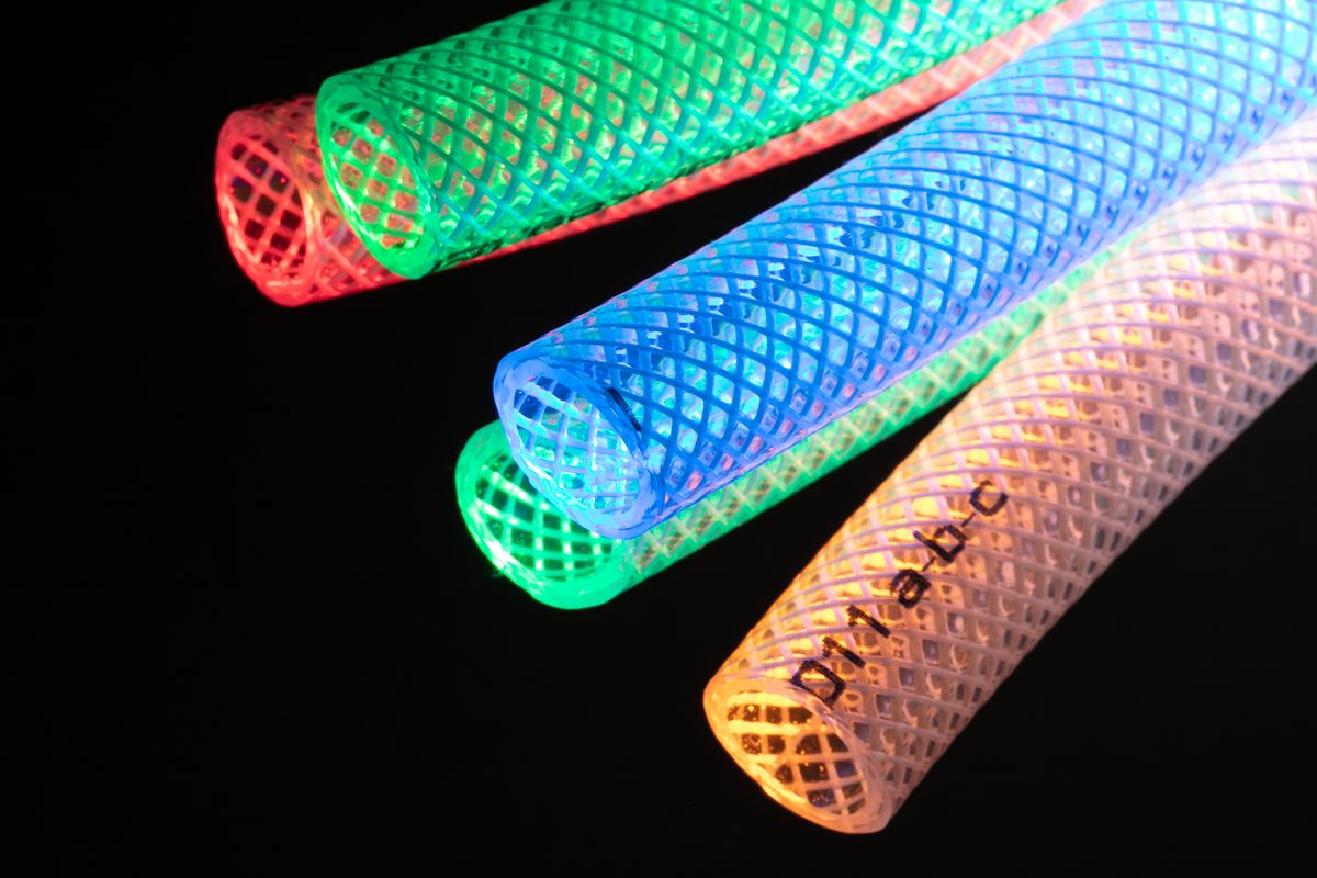 Cut ends of clear braid-reinforced vinyl tubing in several colors, showing the woven reinforcement inside the tube wall