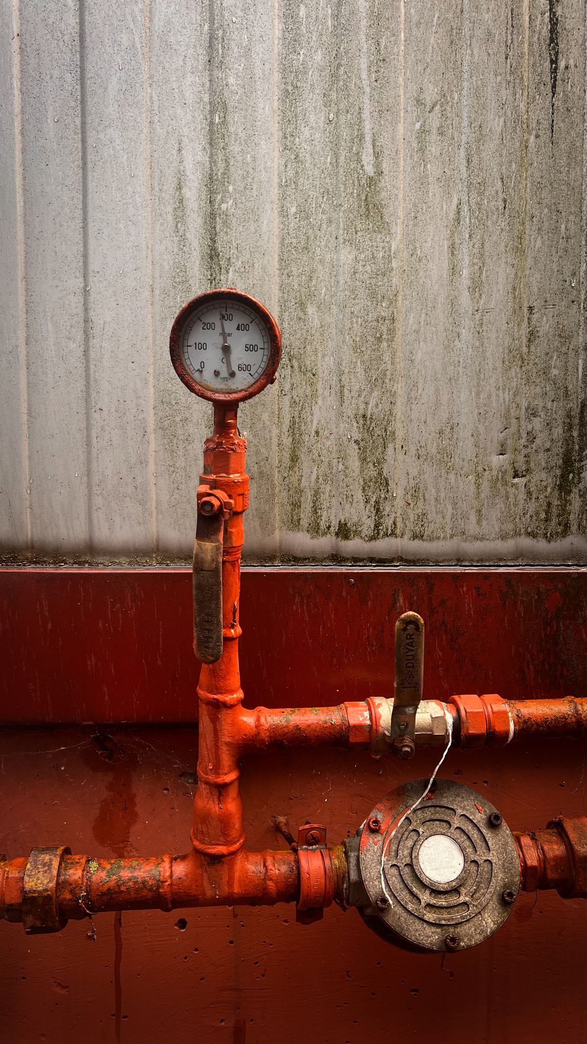 Close-up of a pressure gauge mounted on metal piping, the type of gauge used to measure pressure drop across a sediment filter before a water softener