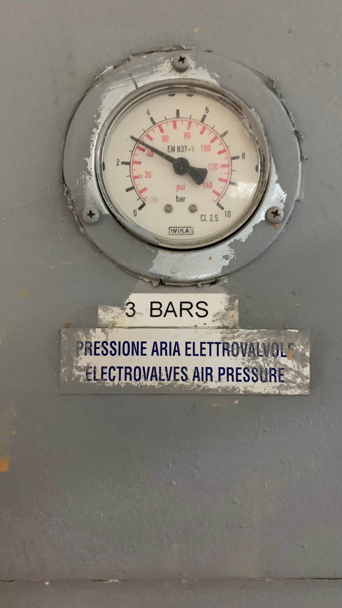 Close-up of a pressure gauge dial reading about three bar in an industrial setting, the scale on which a normal softener pressure drop of a few psi is measured