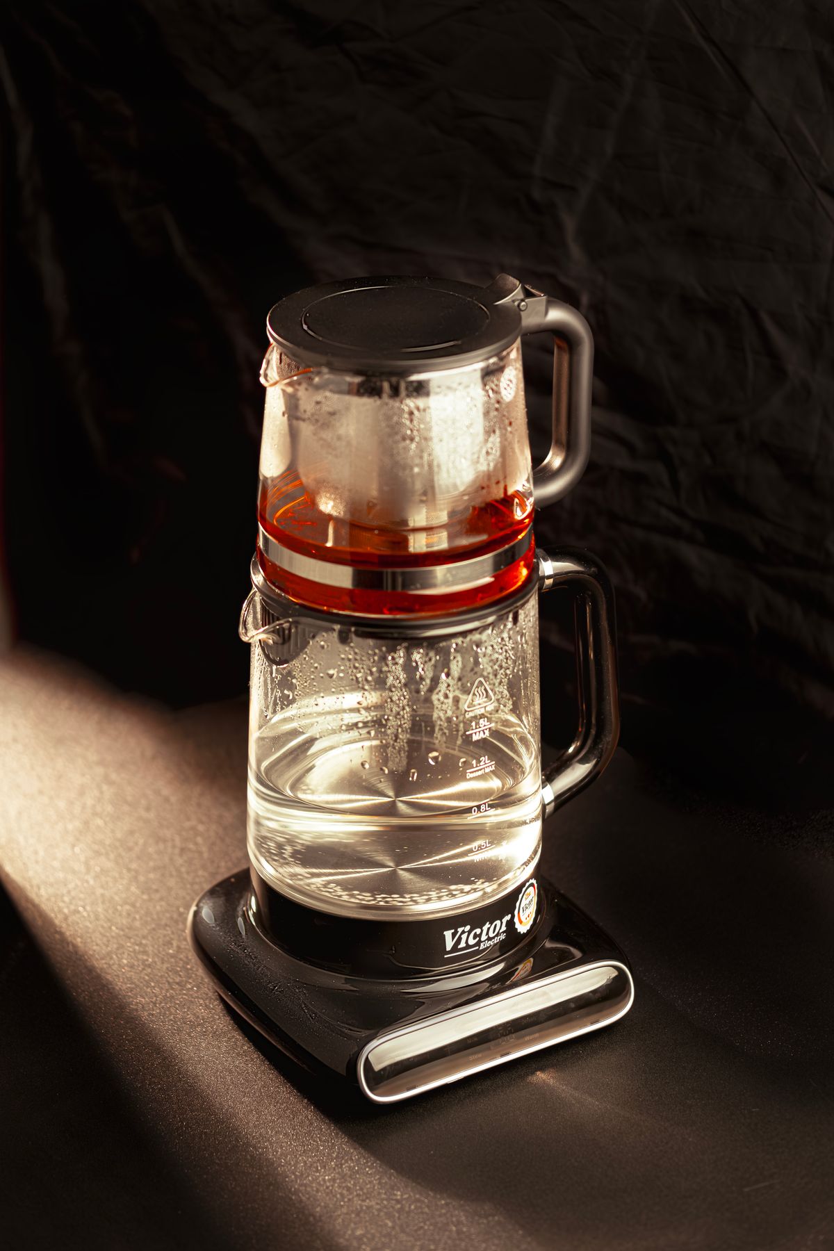 Glass electric kettle steaming, showing the water chamber where scale forms
