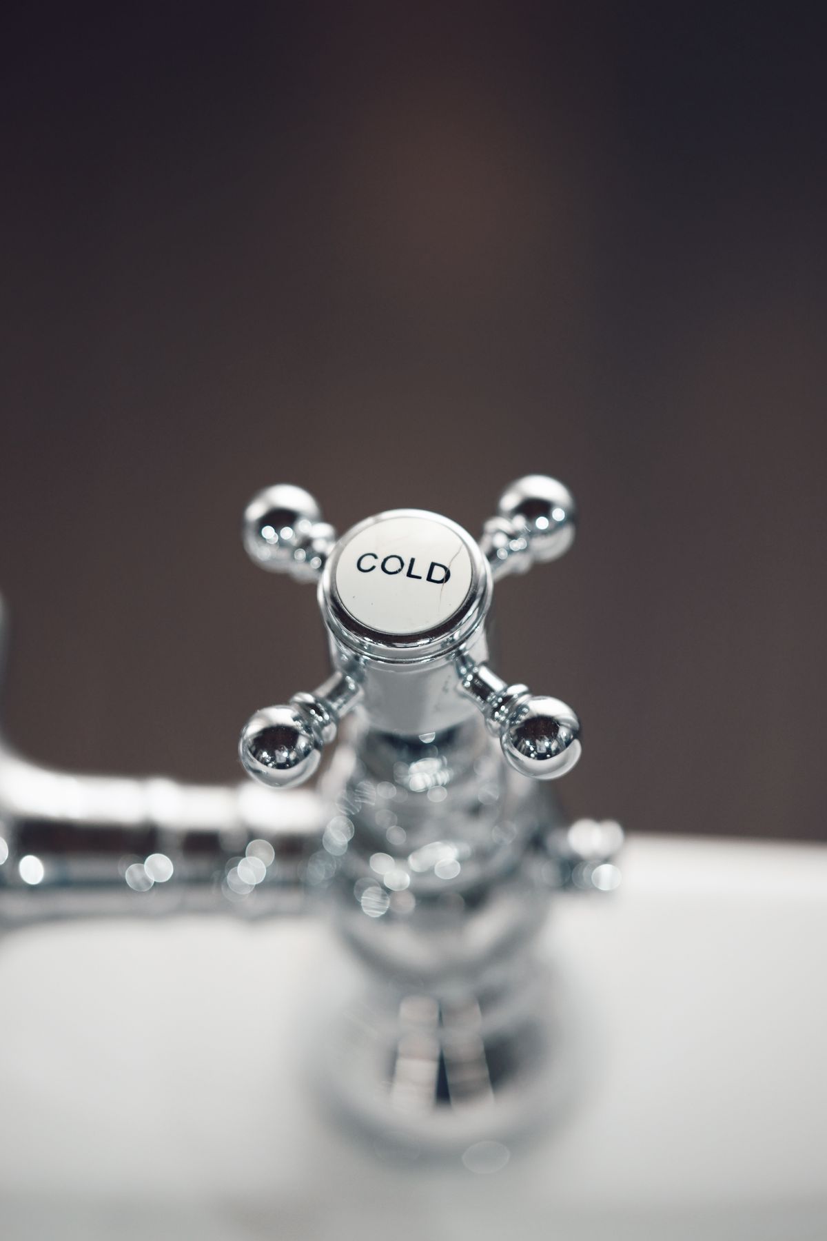 Chrome bathroom faucet with mineral residue around the spout, showing what is hard water scale looks like on fixtures