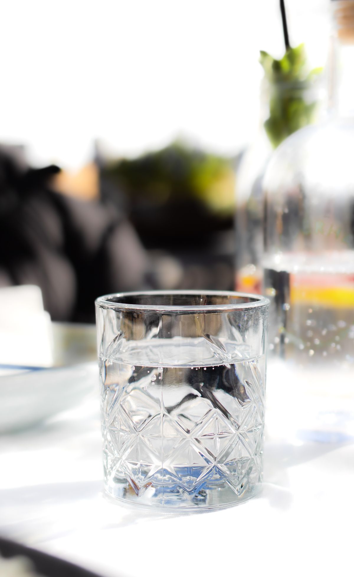 Clear glass of water standing on a sunlit table, the settling test that separates dissolved air from suspended particles