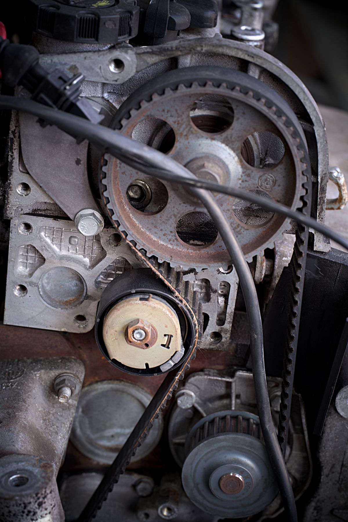 Close-up of a mechanical drive system with toothed gears and a timing belt, comparable to the reduction gears that transmit motor power to a softener valve piston