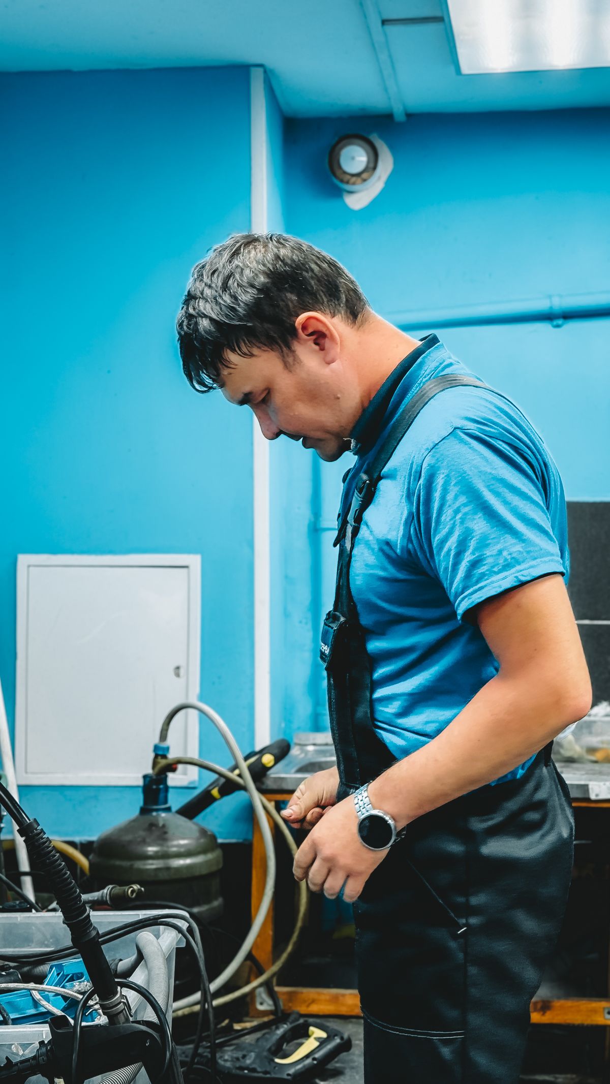 Male technician in a blue workshop setting, representing the trained water treatment professional needed for pressurised valve and tank repairs