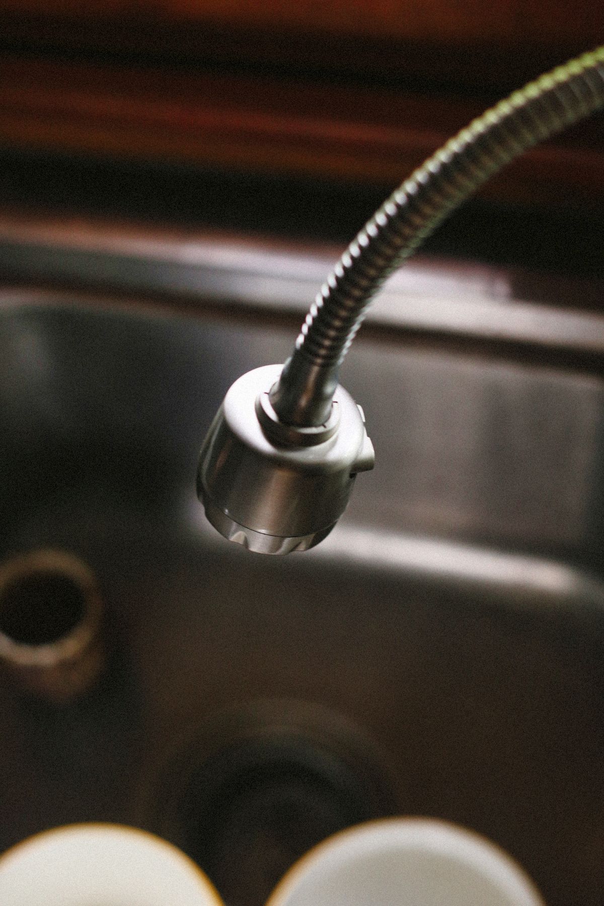 Flexible kitchen faucet over a stainless steel sink, the tap used for the hot-versus-cold odour comparison