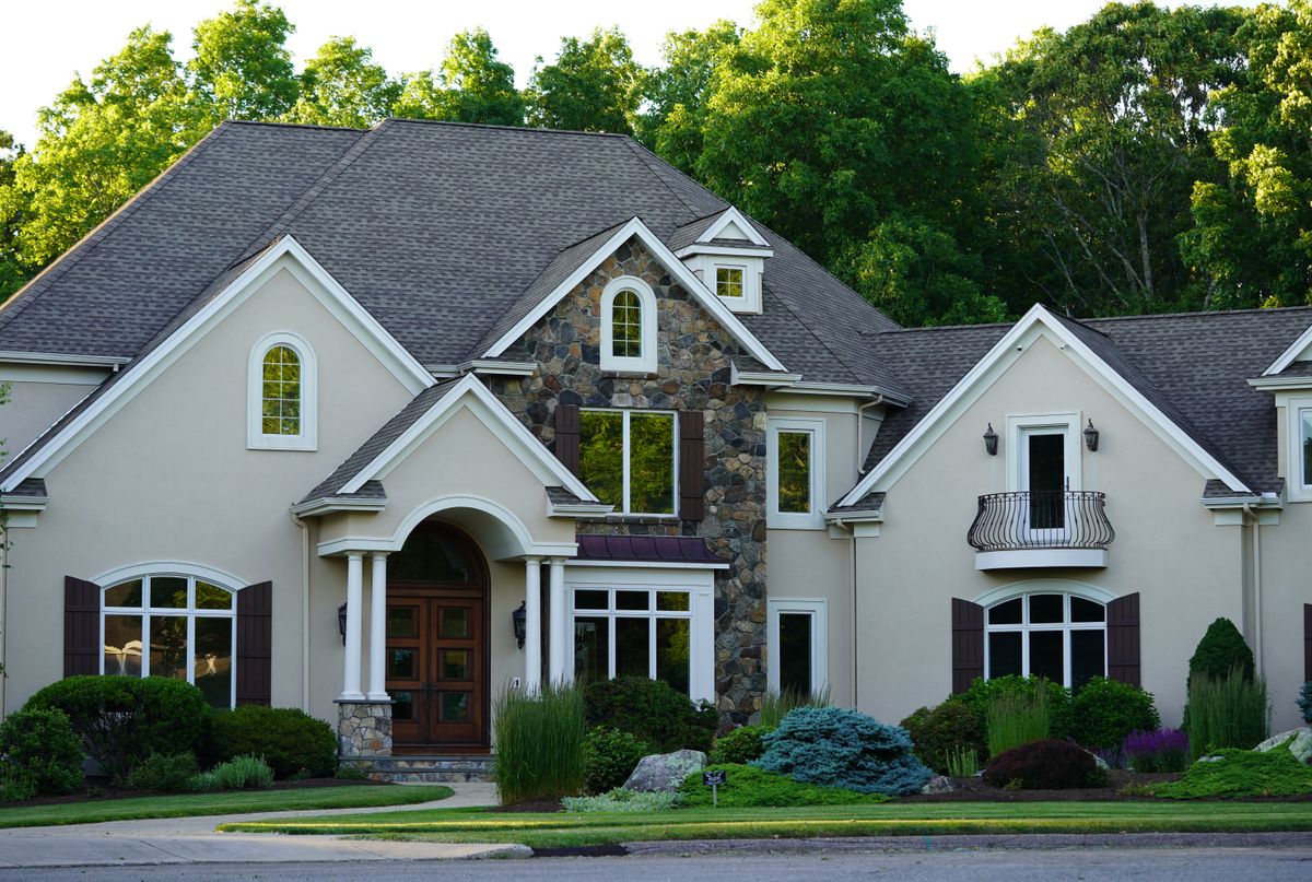 Large two-storey suburban house set among mature trees and lawn, a big rural home whose water use can call for an 80,000 grain softener