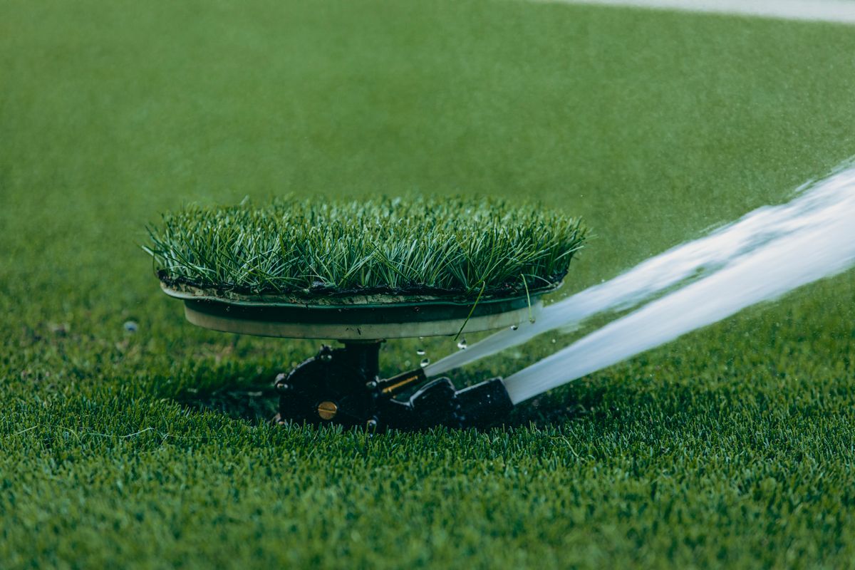 Automatic lawn sprinkler watering a green lawn, an outdoor load that should be plumbed ahead of a large home's water softener