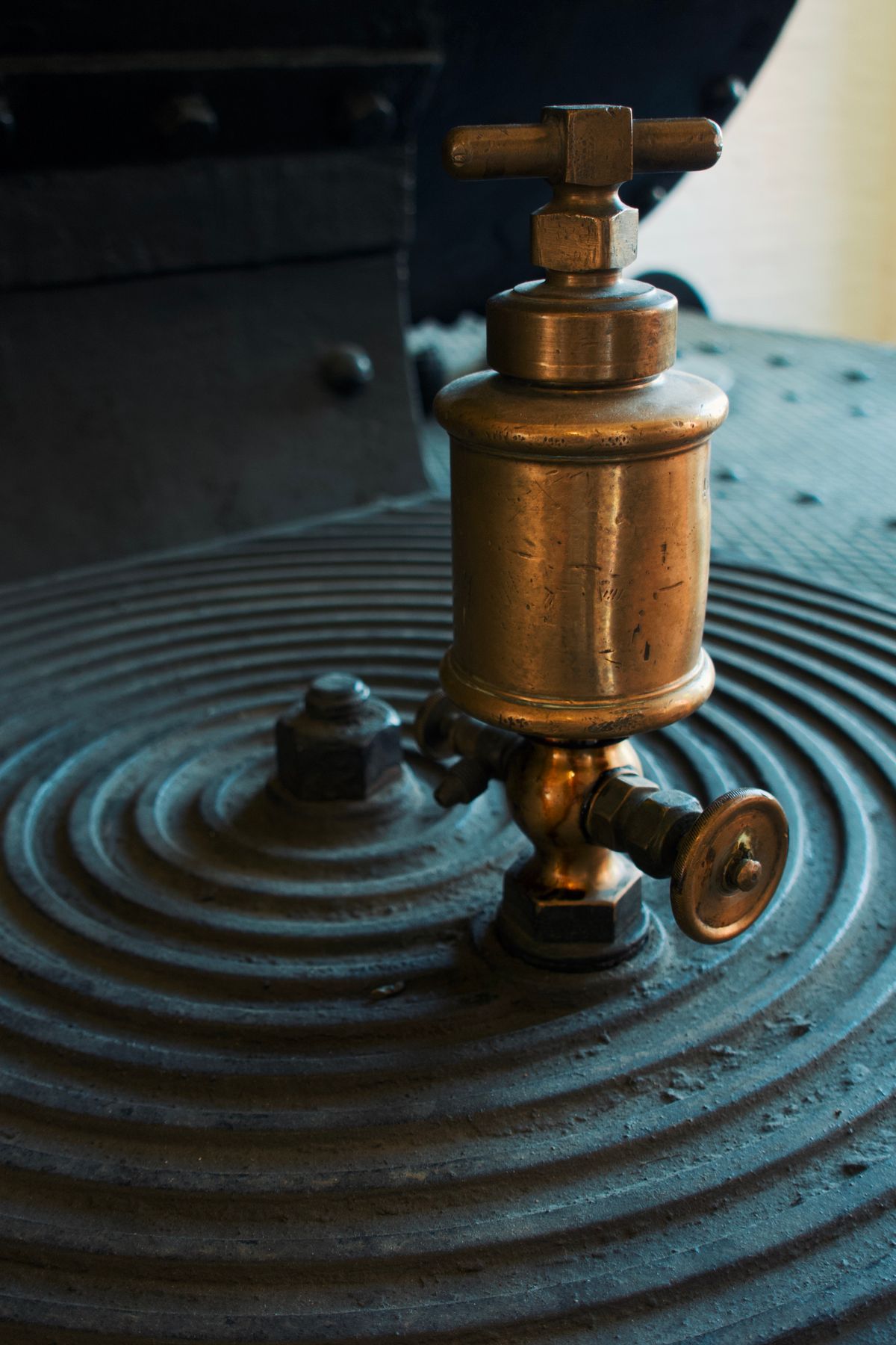 Close-up of an aged brass valve fitting on a metal tank body