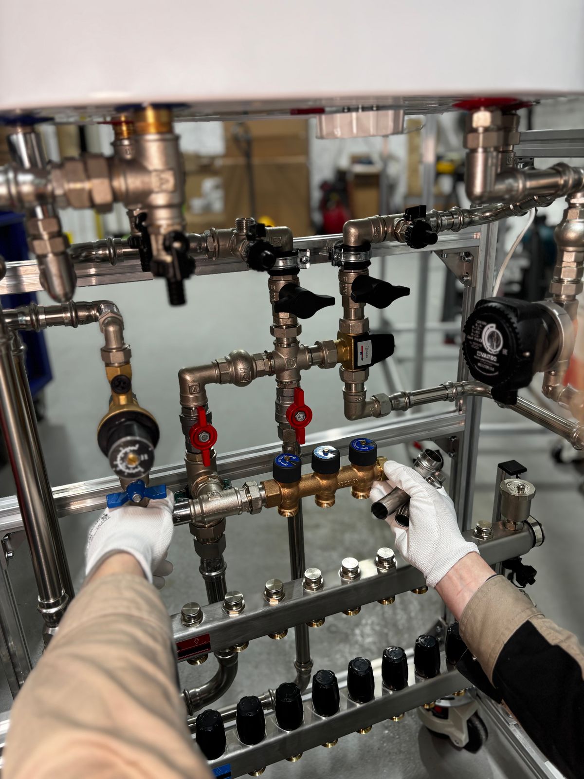 Engineer adjusting metal pipeline valves during a heating system service