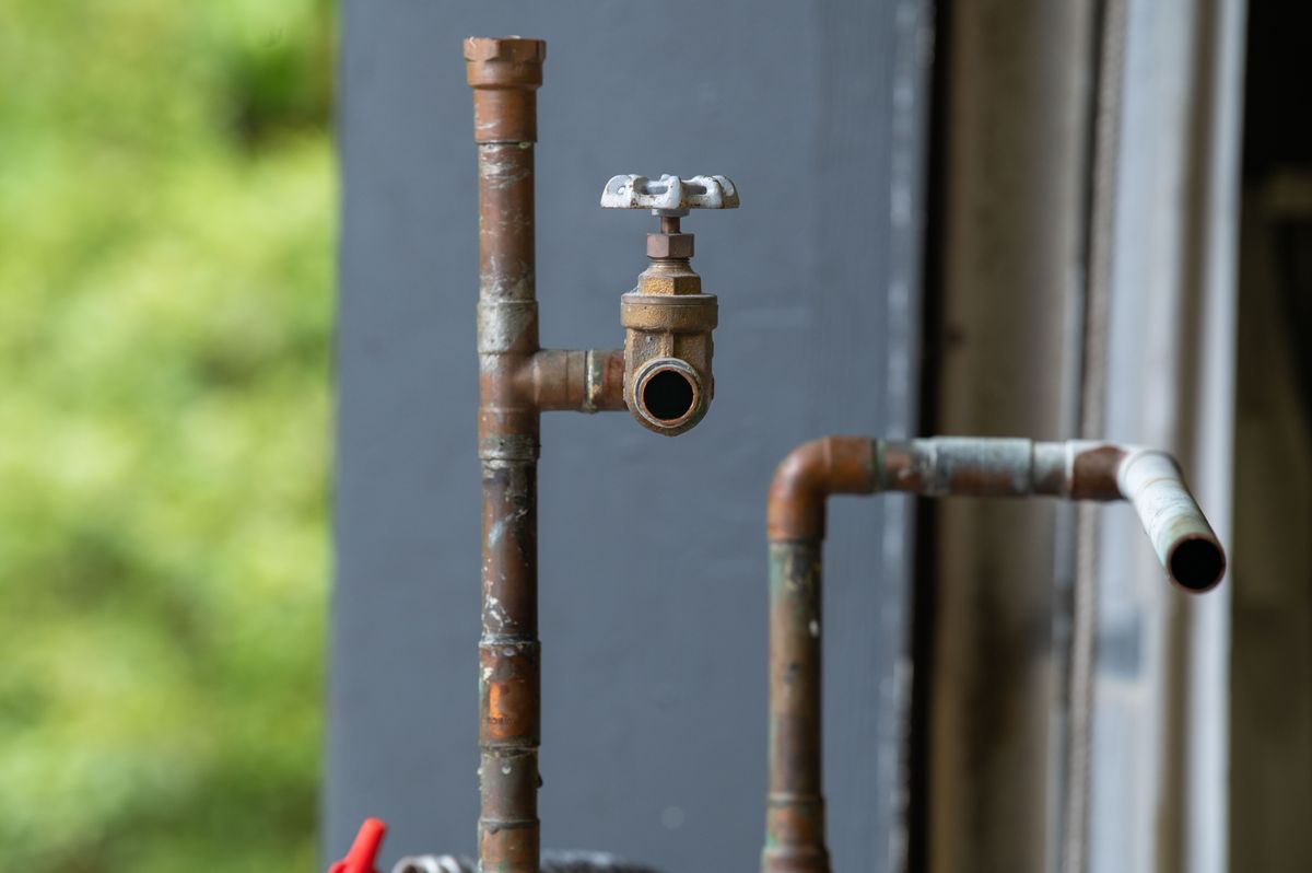 Old iron pipe and valve heavily coated with corrosion product, the same deposit that accumulates on softener resin