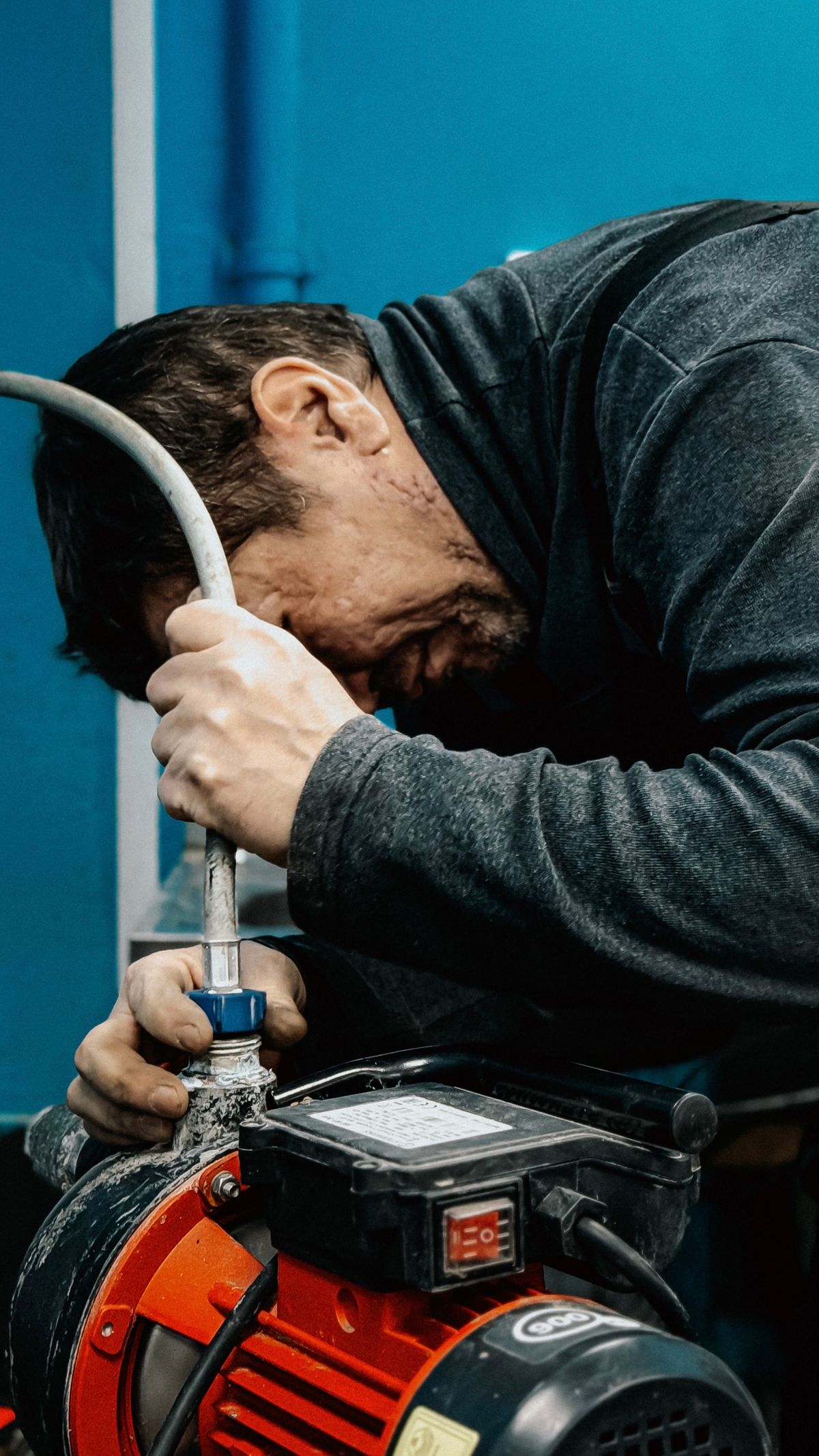Technician adjusting a water pump indoors, the well equipment worth inspecting before buying odour treatment