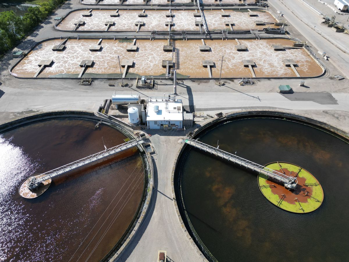 Aerial view of a municipal water treatment plant with circular clarifiers and rectangular basins, where city water picks up its chlorine residual