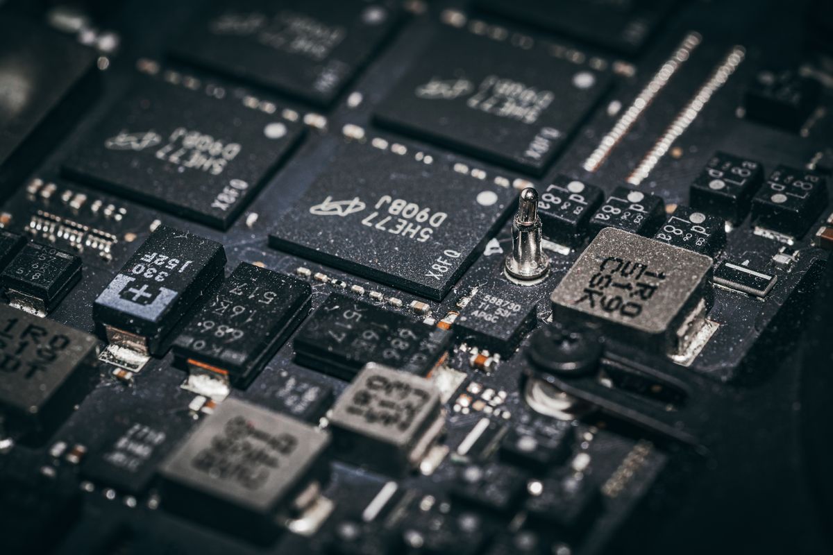Macro view of microchips and surface components on an electronic circuit board, illustrating the sensor and controller circuitry that reports a softener valve's position