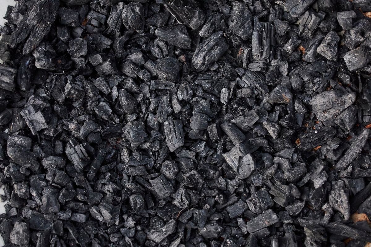Close-up of black granular carbon pieces, the raw material that activated and catalytic carbon prefilter media for water softeners is made from