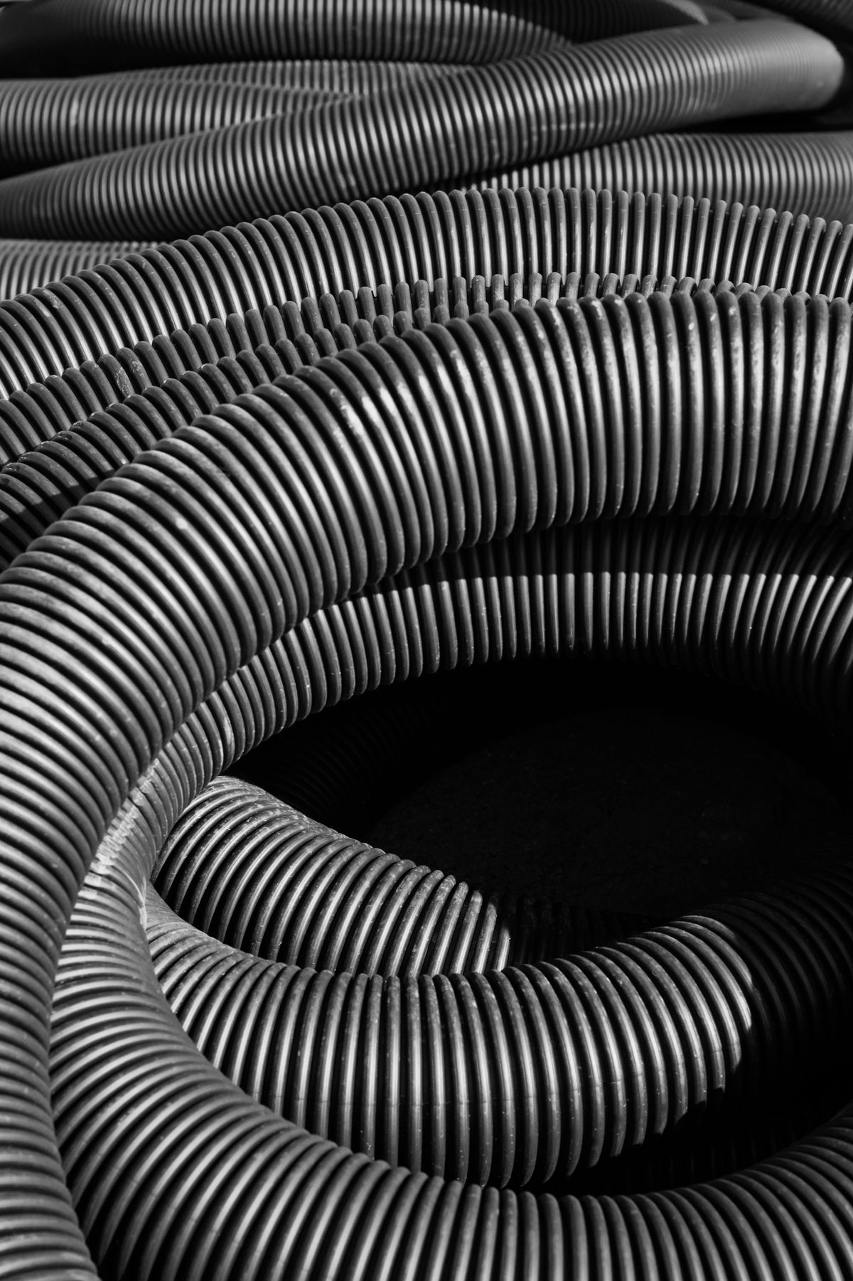 Coiled lengths of corrugated plastic tubing, the flexible kind of line that kinks at tight bends and flattens when a softener drain run is pulled around a corner