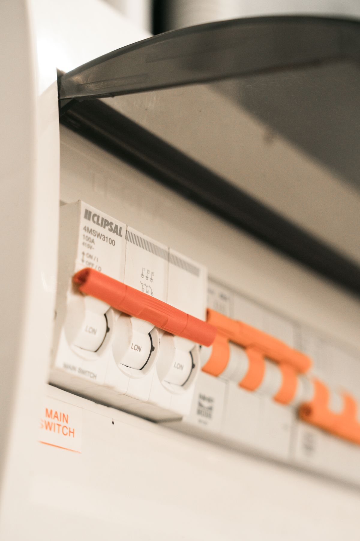 Close-up of a home circuit breaker panel with orange toggle switches, the power supply whose brief interruptions reset a softener clock once its backup has died