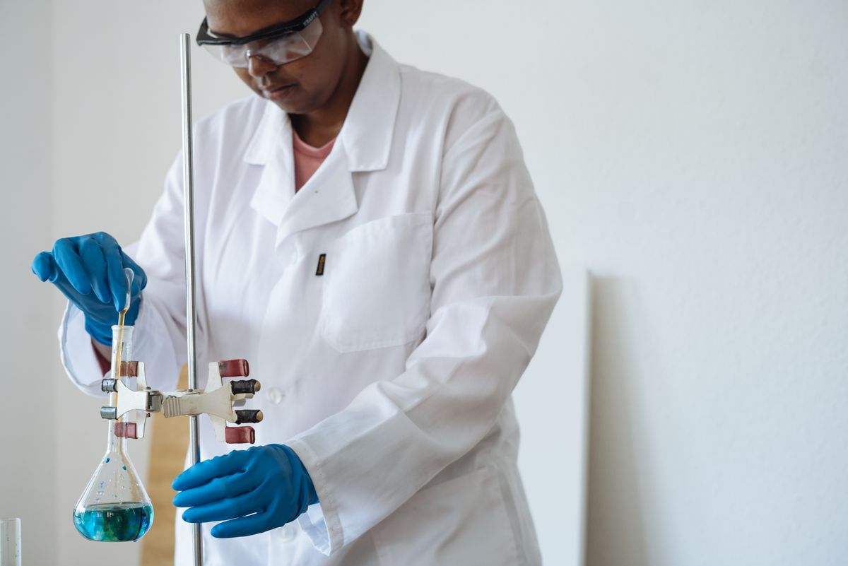 Laboratory technician running a titration with a pipette and flask, the measured hardness testing that sits behind a water softener certification