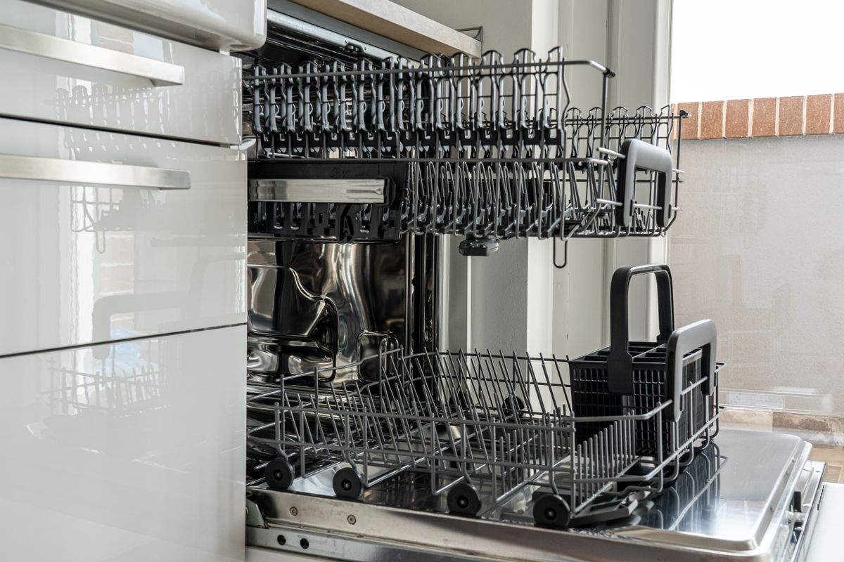 Open, empty dishwasher in a modern kitchen, ready for the no-detergent test cycle that isolates residue from detergent overdose