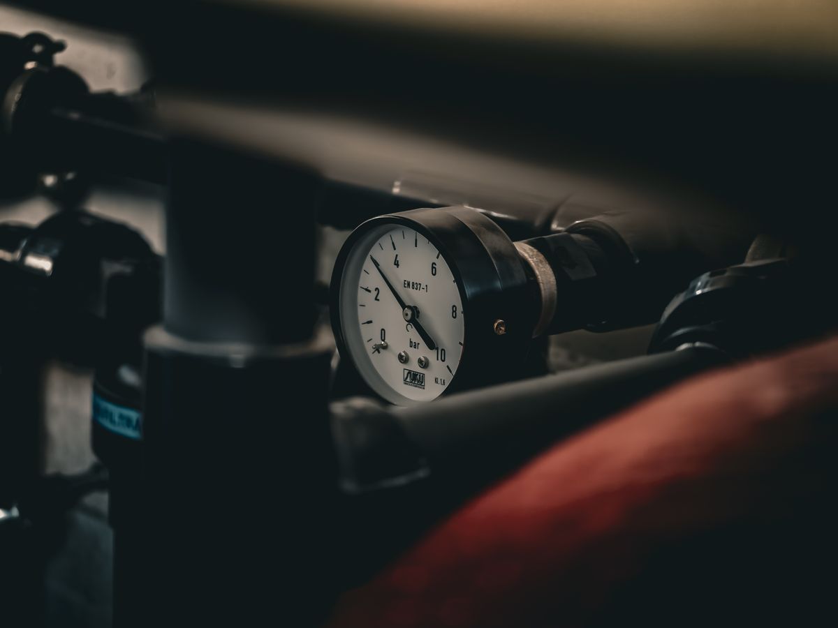 Pressure gauge mounted on an industrial pipe run, the reading that shows whether high house water pressure is wearing out softener control head O-rings