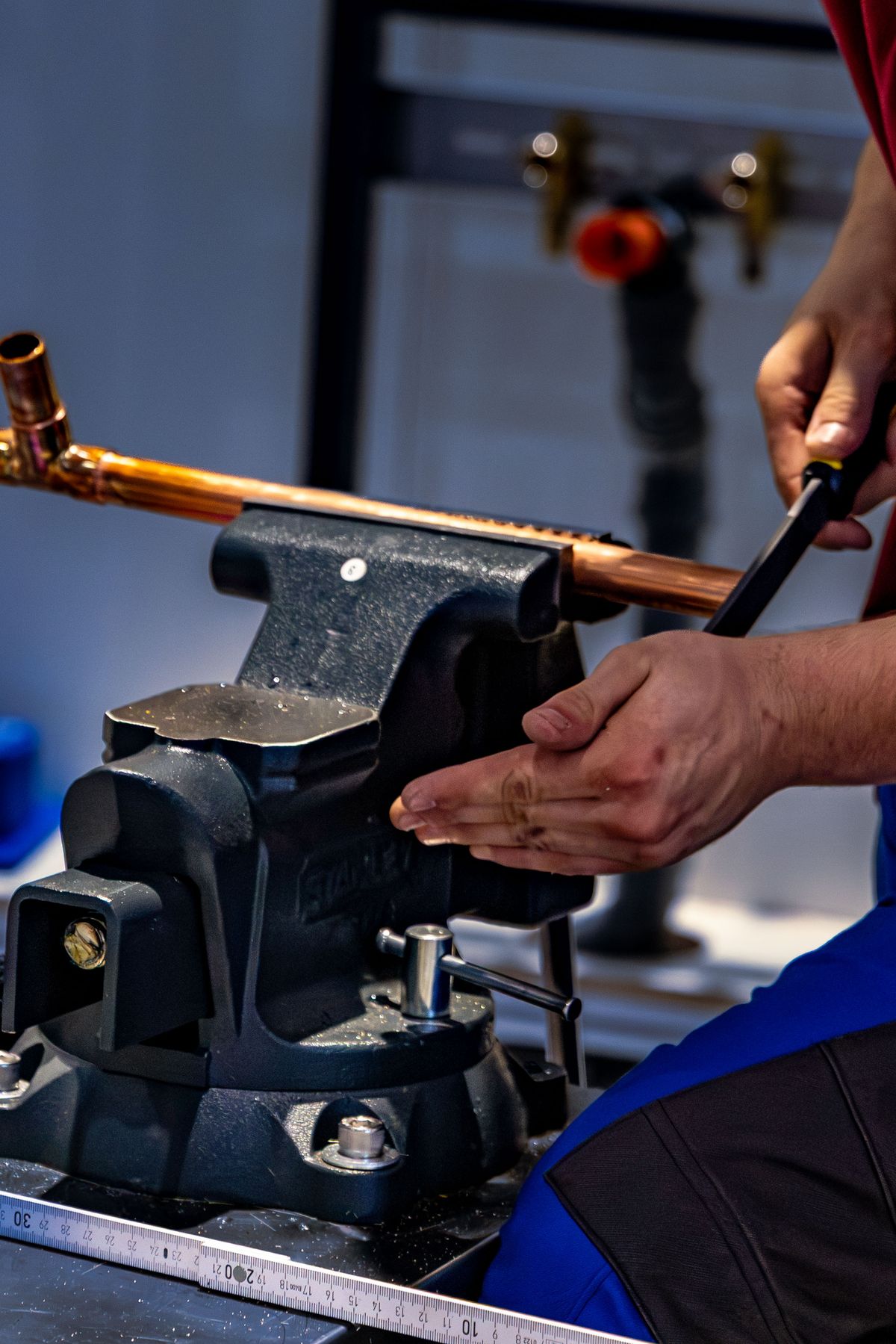 Plumber bending a length of copper pipe with a pipe bender, the household copper plumbing that a Nuvo H2O citric acid system's lower pH can affect