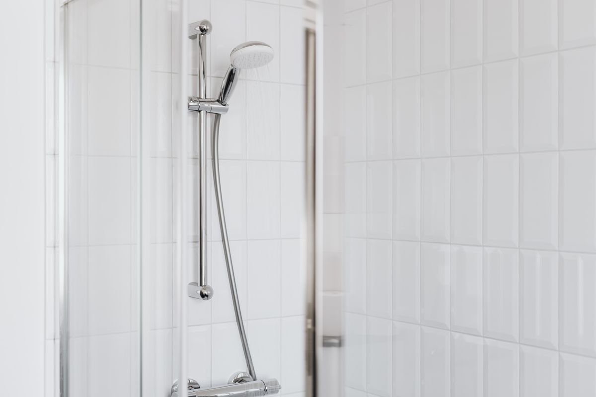 Chrome shower fixtures against clean white tiling in a modern bathroom