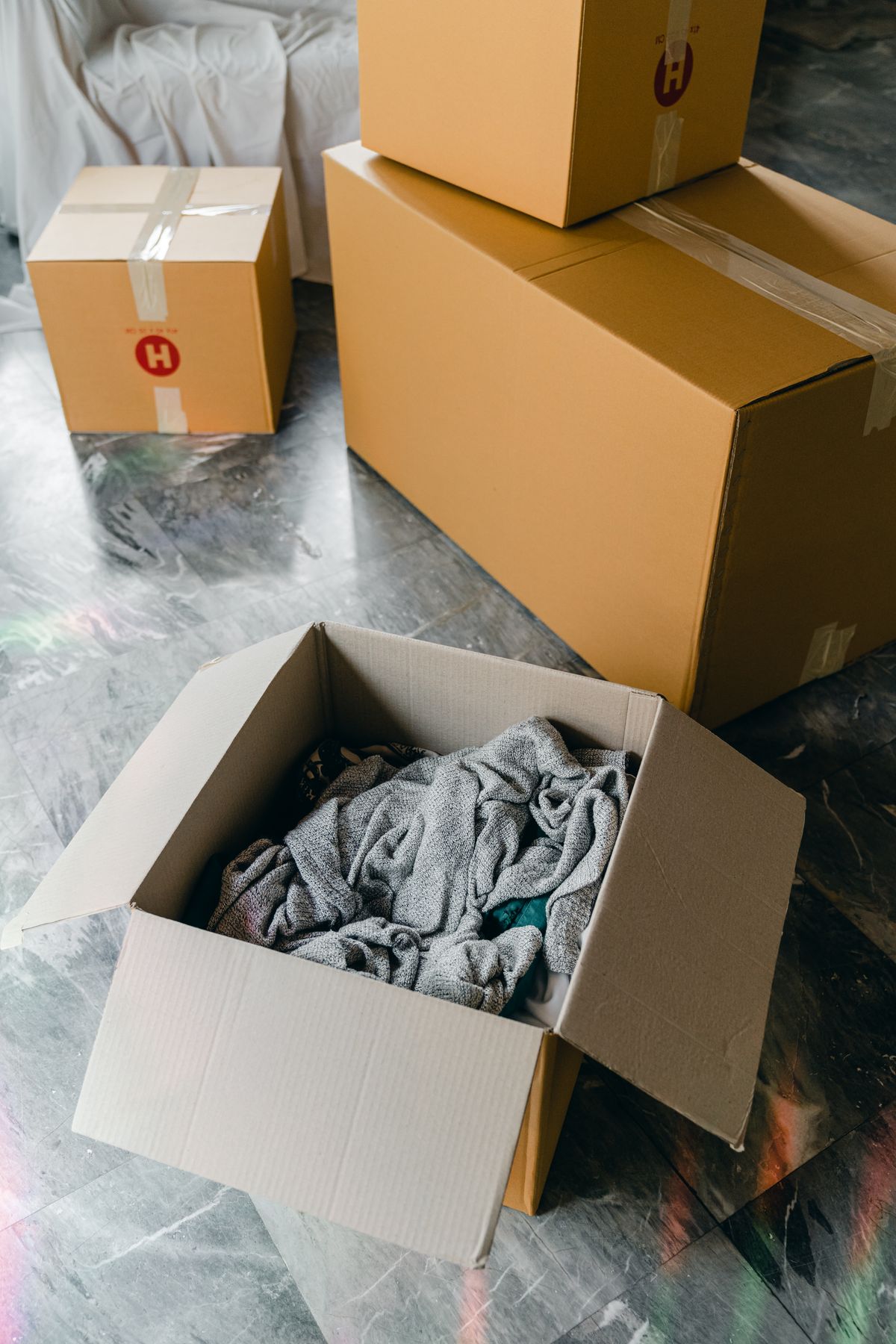 Packed cardboard moving boxes on the floor of an emptied room, a reminder that years left in the home decide whether a whole house water softener pays back