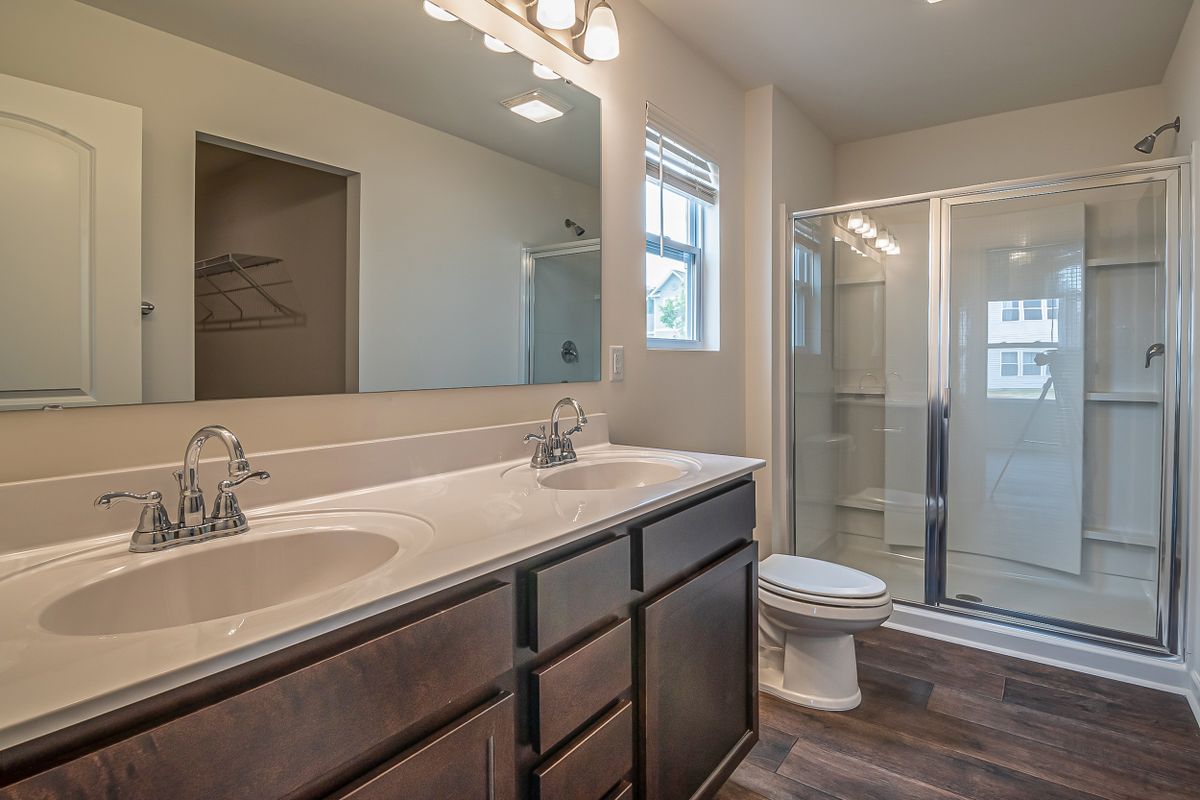 Spacious bathroom with double sinks and a glass shower, the kind of fixtures that add up to a large home's peak water flow