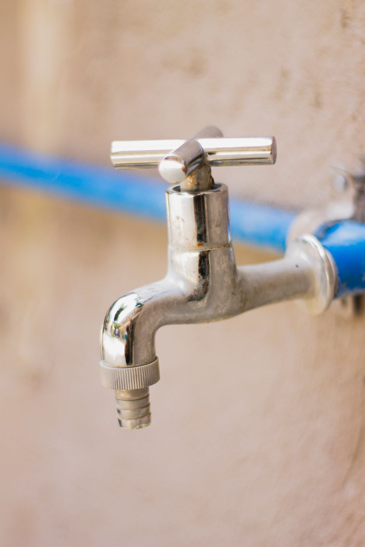Stainless steel faucet connected to a blue supply pipe on a wall, the single-fixture supply that produces a false branch diagnosis