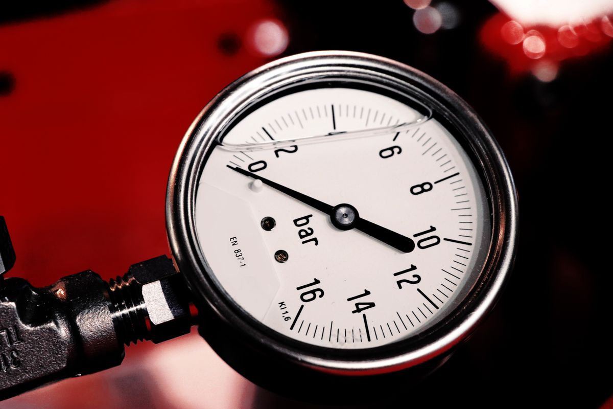 Detailed view of a dial pressure gauge marked in bar, the kind of reading that gets logged on each side of a sediment filter housing