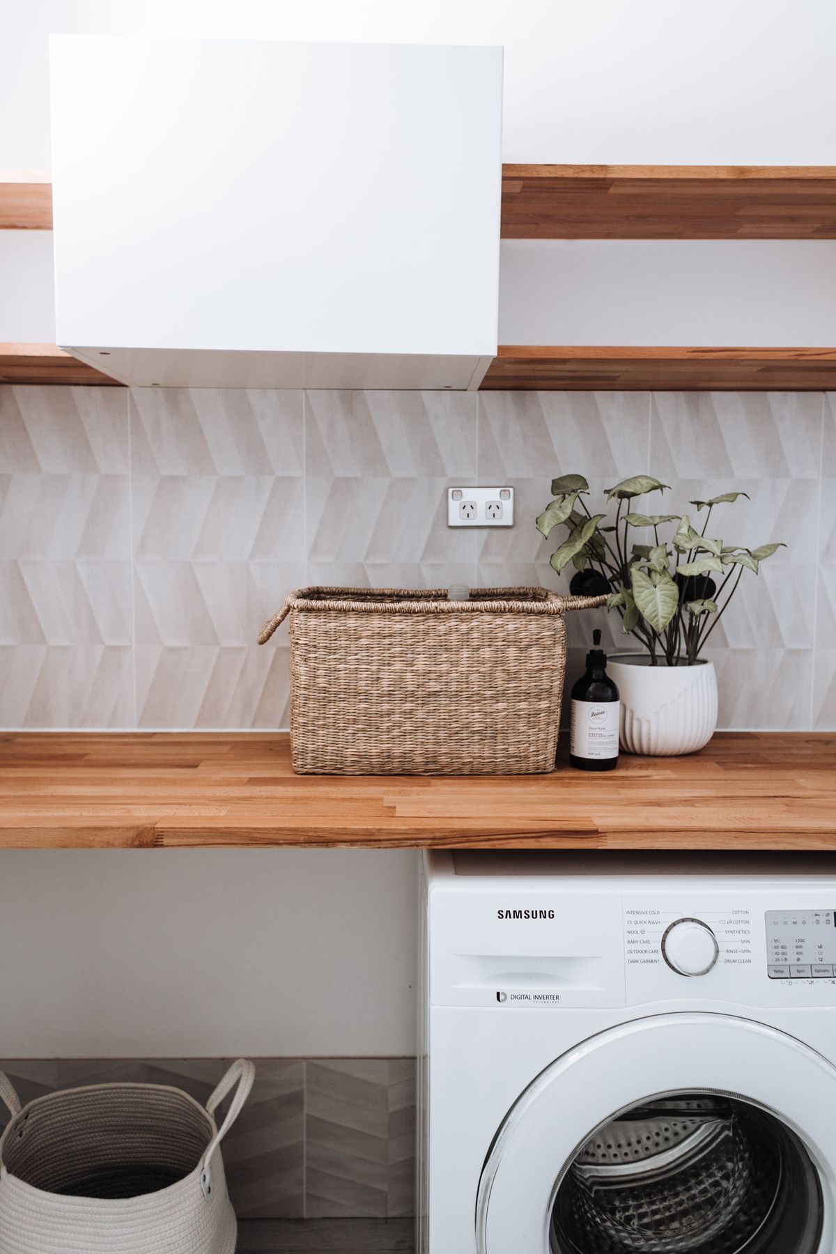 Washing machine in a home laundry corner, one of the fixtures that adds to the peak flow a Whirlpool or GE cabinet softener has to carry