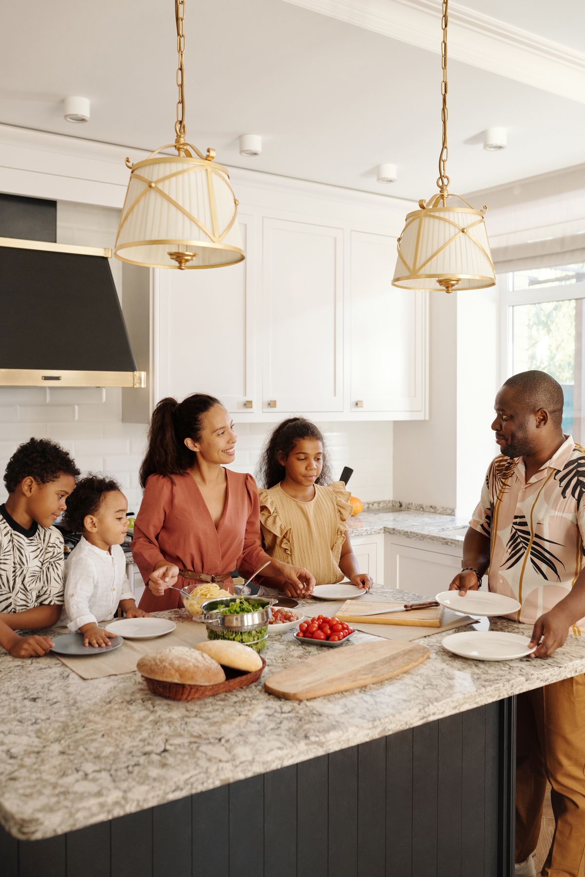 Family of six preparing a meal together at a large kitchen island, the size of household whose daily water use can justify a 64,000 grain softener