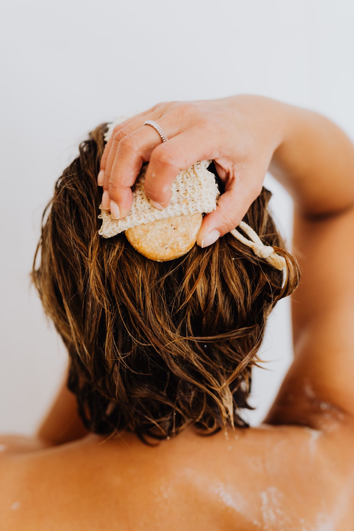 Woman using shampoo in the shower during a chelating wash