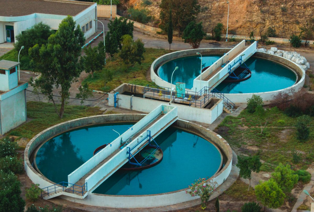 Aerial view of a municipal water purification plant surrounded by trees, the source of the residual disinfectant that reaches a household softener