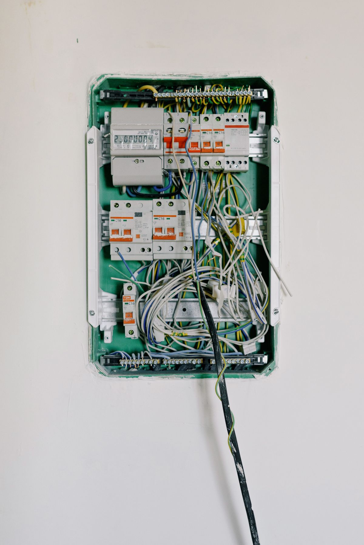 Residential switchboard with circuit breakers and wiring on a white wall, where a tripped breaker is a common reason for a blank water softener display