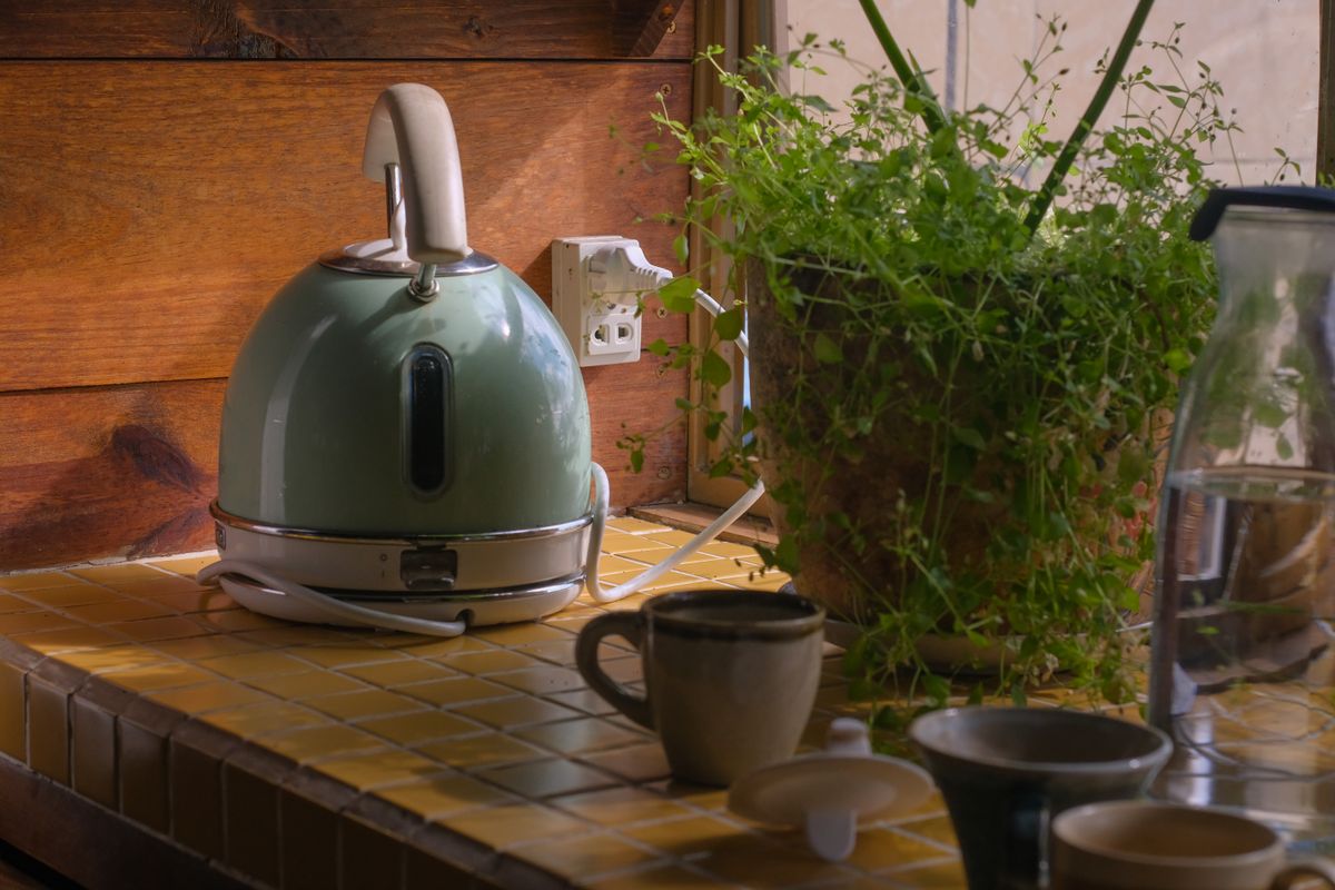 Green electric kettle on a tiled kitchen counter, the everyday appliance that shows within weeks whether an electronic water descaler is cutting scale